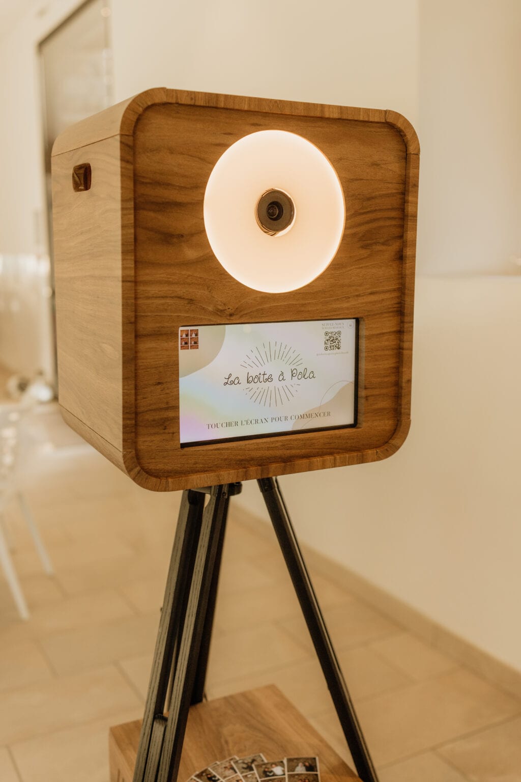Un photobooth en bois de La Boîte à Pola, écran d’accueil allumé, dans une salle de réception